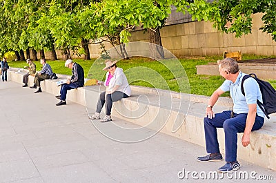 Moscow, Russia, June 11, 2017. Senior tourists and other men sitting outdoors in the city Editorial Stock Photo
