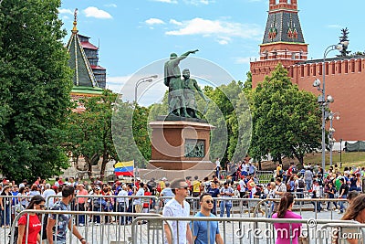 Moscow, Russia - June 21, 2018: Tourists walk on Red square near monument to Minin and Pozharsky against walls and towers of Editorial Stock Photo