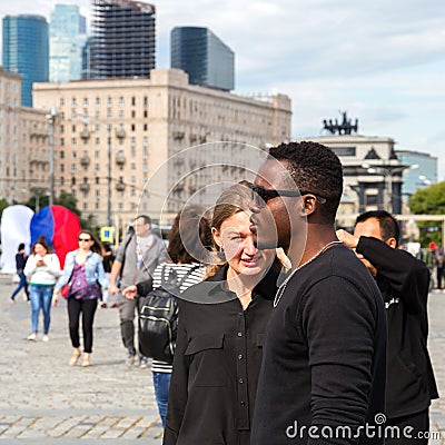 Young interracial couple of students in the city square in the summer Editorial Stock Photo