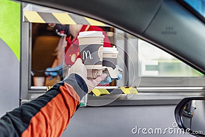 Moscow, Russia, 30/05/2020: A man takes an order from a delivery window to McDonald`s. Drive thru Editorial Stock Photo