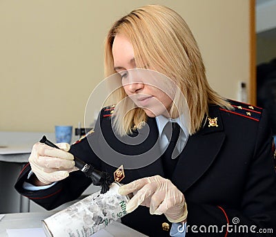 Forensic expert police pulls fingerprints found on the can of the crime scene. Editorial Stock Photo