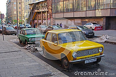 Green and yellow soviet motor cars VAZ 2101 Zhiguli standing on the Arbat in Moscow Editorial Stock Photo