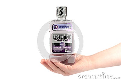 Moscow, Russia - March 01, 2021: Listerine Total Care 6 in 1 bottle with oral protection liquid on a woman's palm. Editorial Stock Photo