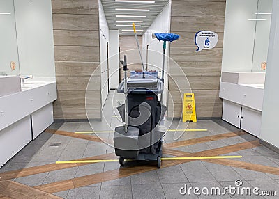 MOSCOW, Russia, May 2021: A cleaning cart with mops in an empty public toilet. On the floor dividing lines for social distance, Editorial Stock Photo