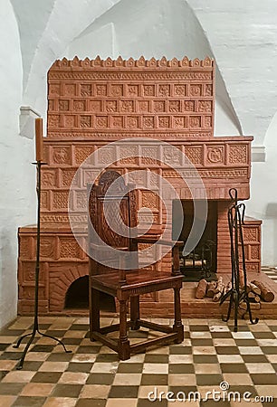 Moscow. Russia - May 12, 2019: authentic historical medieval interior with a wooden chair, candles and a fireplace with tiles Editorial Stock Photo