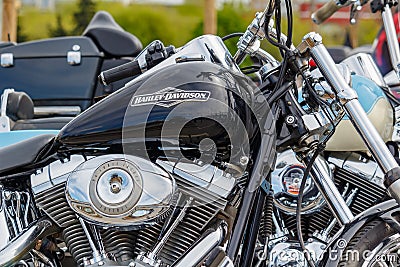 Moscow, Russia - May 04, 2019: Glossy black fuel tank with Harley Davidson motorcycles emblem and chromed engine closeup. Moto Editorial Stock Photo