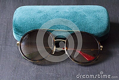 Moscow, Russia, May 20, 2020. Gucci sunglasses are popular high-end brand, created for men, women, with round dark lenses lie on Editorial Stock Photo