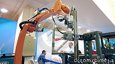MOSCOW, RUSSIA - MAY 26, 2021. KUKA Robotics robot arm with welding equipment imitates welding of steel pieces at the Editorial Stock Photo