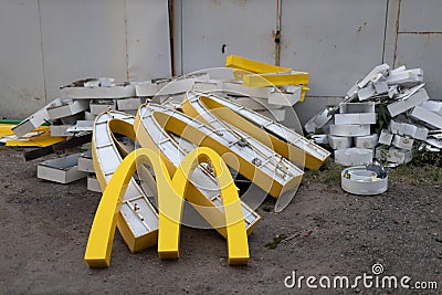 Moscow, Russia - 06.21.2022: McDonalds logo letter character M on dirty rubbish heap dump trash litter garbage. Fast Editorial Stock Photo