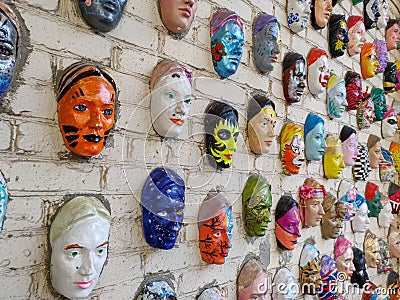Moscow, Russia, 21 October 2019: Colorful painted ceramic faces sculpture on the bricks wall as an the object of modern Editorial Stock Photo