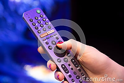 Moscow, Russia - October 04, 2019: female hand holds a smart TV remote with an android button with microphone and voice Editorial Stock Photo