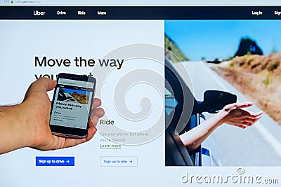 The home Internet page of the mobile application Uber.com on the screen the smartphone in male hand on a against the background co Editorial Stock Photo