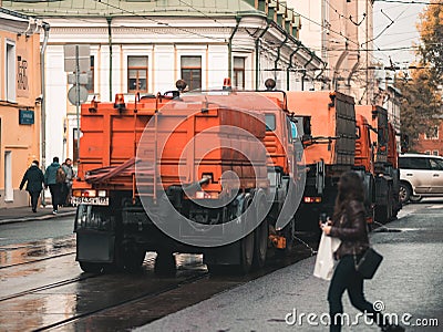 Irrigation sweepers trucks stand on the tram tracks in front of the intersection in anticipation of a green traffic light. Woman p Editorial Stock Photo
