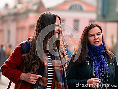 Moscow, Russia - October 19, 2019: Two girlfriends walk along the street and have a fun conversation. Young women are walking in Editorial Stock Photo