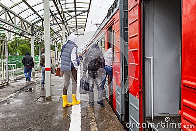 Moscow, Russia, 31/05/2020: People go into the open doors of a train standing on the platform Editorial Stock Photo