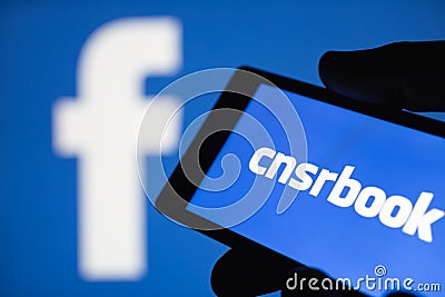 Logo of the Facebook blurred on background. The concept of censorship on popular social networks. Shallow DOF Editorial Stock Photo