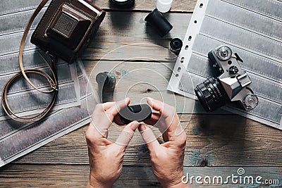 Moscow. Russia - 04 23 2020: top view of woman hands, photographer with analog cameras, film, lenses on old wooden table Editorial Stock Photo