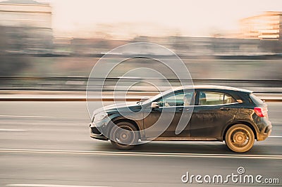 A woman drives a car at high speed. A black car drives fast through the city with motion blur effect Editorial Stock Photo