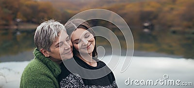 Mother and adult daughter on autumn background Stock Photo