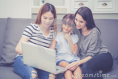 Mother, Aunt and kid having time together lerning with using laptop computer at home Stock Photo