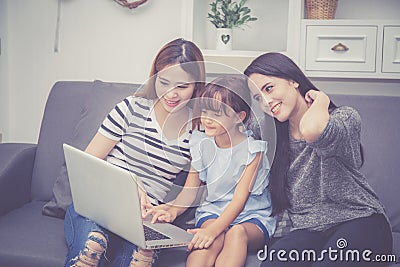 Mother, Aunt and kid having time together lerning with using laptop computer at home with relax and happy on couch Stock Photo