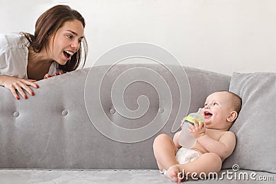 Mother and baby boy are playing on couch Stock Photo