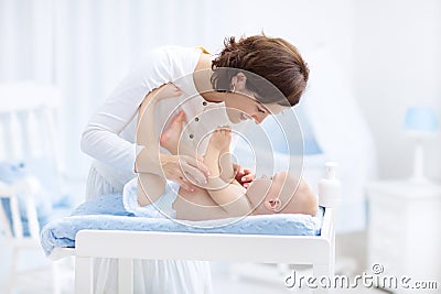 Mother and baby in diaper on changing table Stock Photo