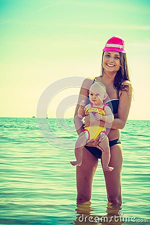 Woman in funny hat hugging baby water Stock Photo