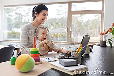 Mother with baby and laptop working at home office Stock Photo