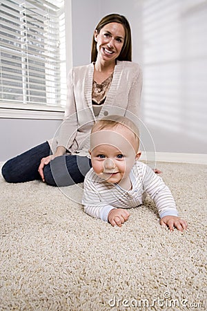 Mother with baby learning to crawl Stock Photo