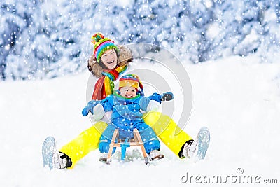 Mother and baby on sleigh ride. Winter snow fun. Stock Photo