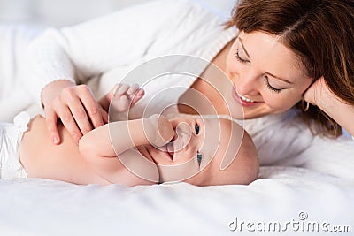 Mother and baby on a white bed Stock Photo