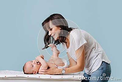 Mother bent over her infant talking, caring and playing with him Stock Photo