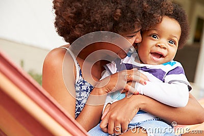 Mother bonding with young son sitting in a hammock Stock Photo