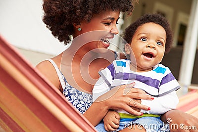 Mother bonding with young son sitting in a hammock Stock Photo