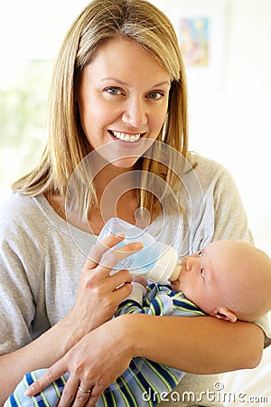 Mother bottle feeding baby Stock Photo