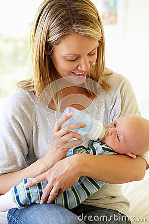 Mother bottle feeding baby Stock Photo