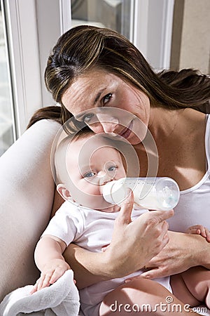 Mother bottle feeding six month old baby Stock Photo