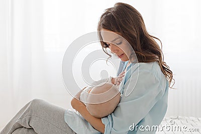 Mother breast feeding and hugging her baby boy Stock Photo