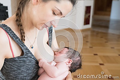 The mother is breastfeeding the baby. mother breastfeeds and hugs the baby, close-up breast. Mom breastfeeds her newborn baby. Stock Photo