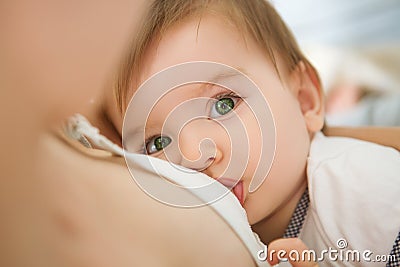 Mother is breastfeeding her baby at home. Mother breastfeeding baby in her arms at home Stock Photo