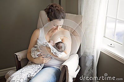 Mother breastfeeding her little baby boy in arms. Stock Photo