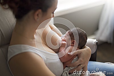 Mother breastfeeding her little baby boy in arms. Stock Photo