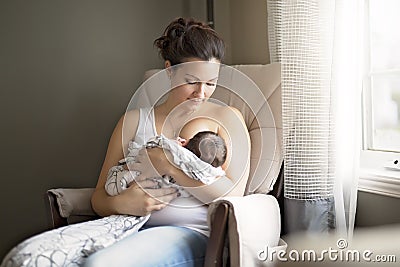 Mother breastfeeding her little baby boy in arms. Stock Photo