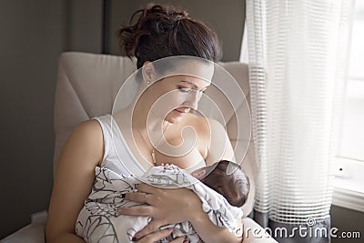 Mother breastfeeding her little baby boy in arms. Stock Photo