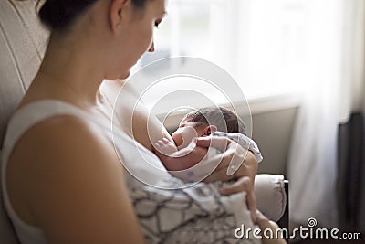 Mother breastfeeding her little baby boy in arms. Stock Photo