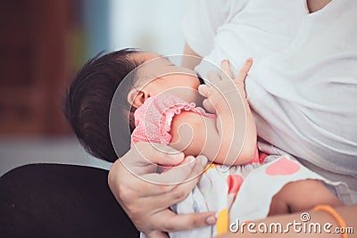 Mother breastfeeding her newborn baby girl. Stock Photo