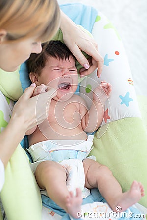 Mother calms newborn baby. Child is crying and screaming during colic Stock Photo