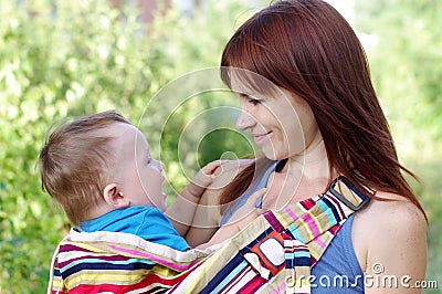 Mother carrys son in baby sling Stock Photo