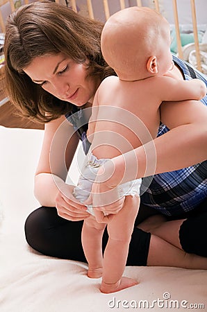 Mother changing baby's diaper Stock Photo